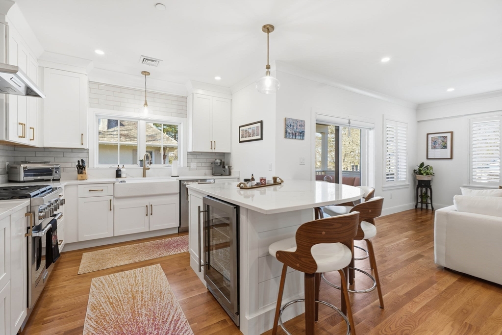 20 Lawrence Street, Unit 2 Wakefield, MA 01880 - Photo 12 of 38 a kitchen with a dining table chairs stove and white cabinets