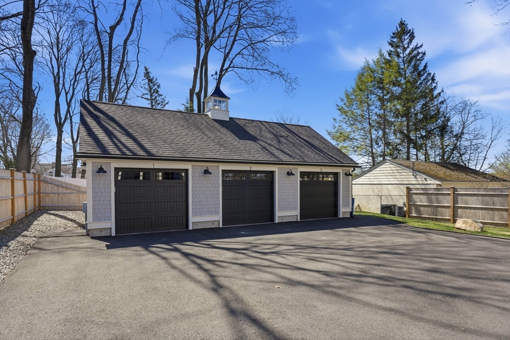 20 Lawrence Street, Unit 2 Wakefield, MA 01880 - Photo 7 of 38 a front view of a house with a yard and garage