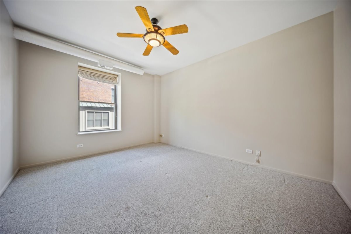 811 South Lytle Street, Unit 101 Chicago, IL 60607 - Photo 17 of 23 an empty room with a window and a ceiling fan