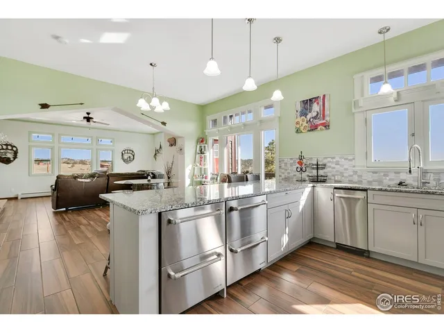 a kitchen with kitchen island granite countertop a sink cabinets and stainless steel appliances