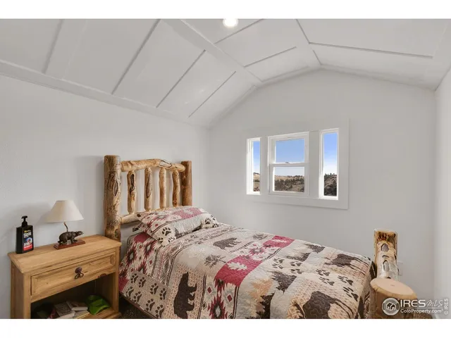 a bedroom with a bed and a painting on the wall