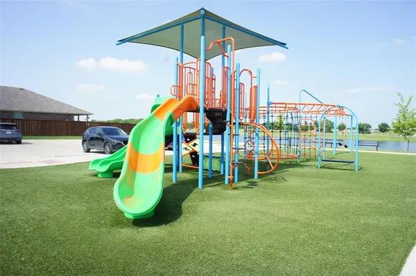 a view of a park with a slide and potted plants