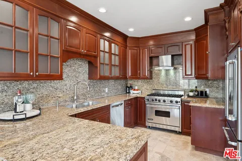 a kitchen with stainless steel appliances granite countertop a stove a sink and a microwave