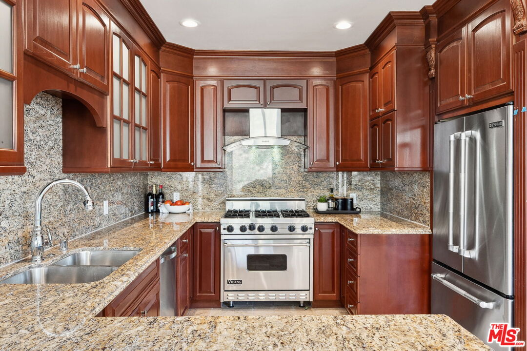 8031 Floral Avenue Los Angeles, CA 90046 - Photo 13 of 34 a kitchen with stainless steel appliances granite countertop a stove top oven a sink and dishwasher