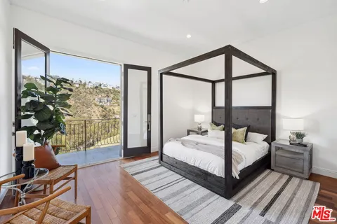 a bedroom with a bed and a large window