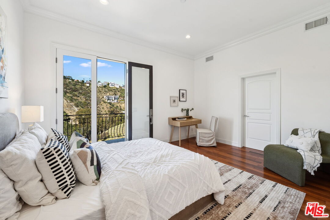 8031 Floral Avenue Los Angeles, CA 90046 - Photo 26 of 34 a spacious bedroom with a bed and wooden floor