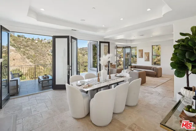 a dining room with furniture a large window and a chandelier