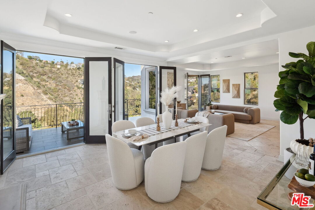 8031 Floral Avenue Los Angeles, CA 90046 - Photo 5 of 34 a dining room with furniture a large window and a chandelier