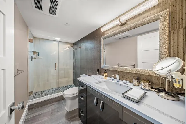 a bathroom with a double vanity sink toilet and shower