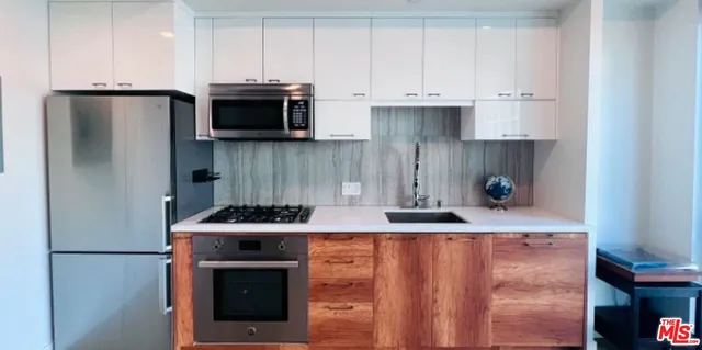 a kitchen with stainless steel appliances granite countertop a stove a refrigerator and a cabinets