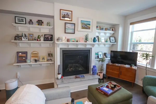 a kitchen with stainless steel appliances kitchen island granite countertop a refrigerator a stove a sink and white cabinets with wooden floor