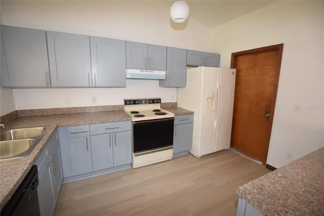 a kitchen with stainless steel appliances granite countertop a refrigerator stove and sink