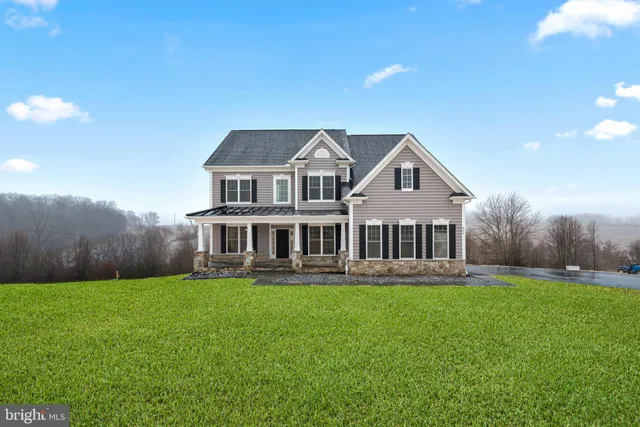 a front view of a house with a garden and trees