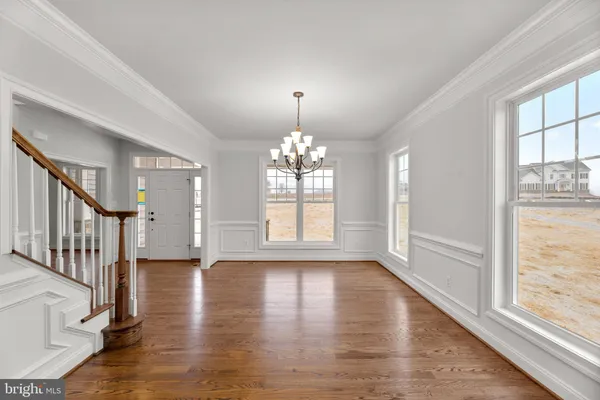 a view of an empty room with wooden floor fireplace and a window