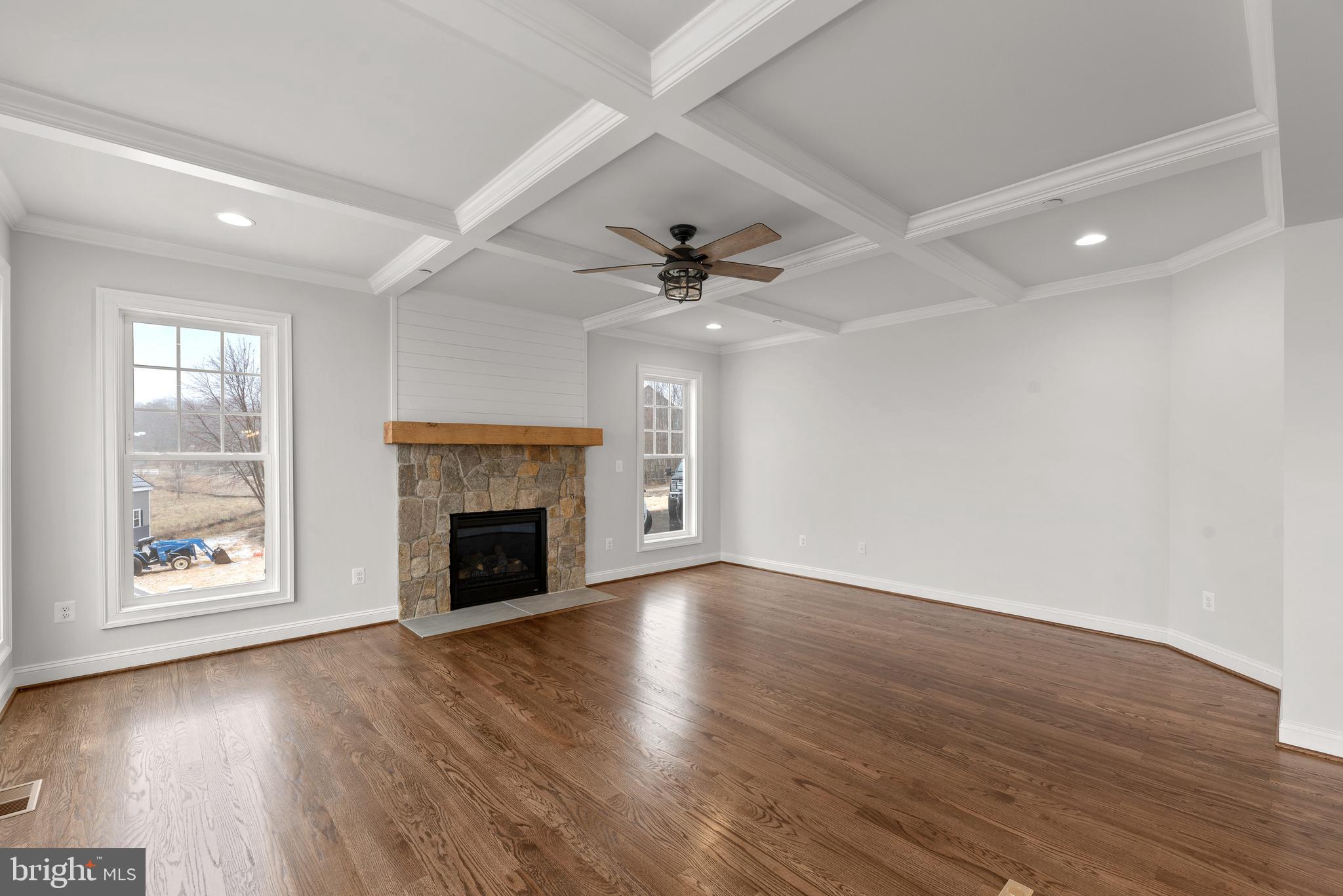 14628 Old Hanover Road, Unit TULARE Reisterstown, MD 21136 - Photo 15 of 60 an empty room with wooden floor fireplace fan and windows