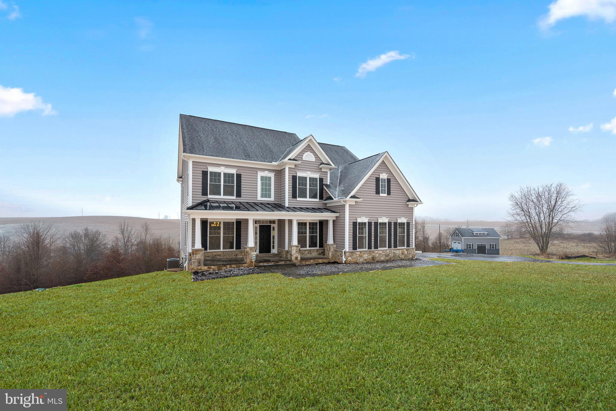 14628 Old Hanover Road, Unit TULARE Reisterstown, MD 21136 - Photo 2 of 60 a front view of a house with a garden and trees