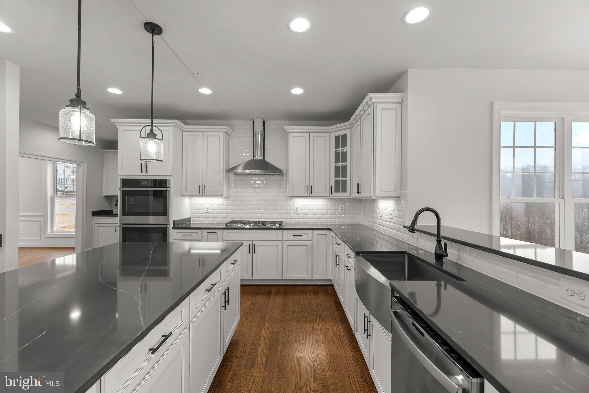 14628 Old Hanover Road, Unit TULARE Reisterstown, MD 21136 - Photo 24 of 60 a kitchen with stainless steel appliances granite countertop sink stove and white cabinets with wooden floor