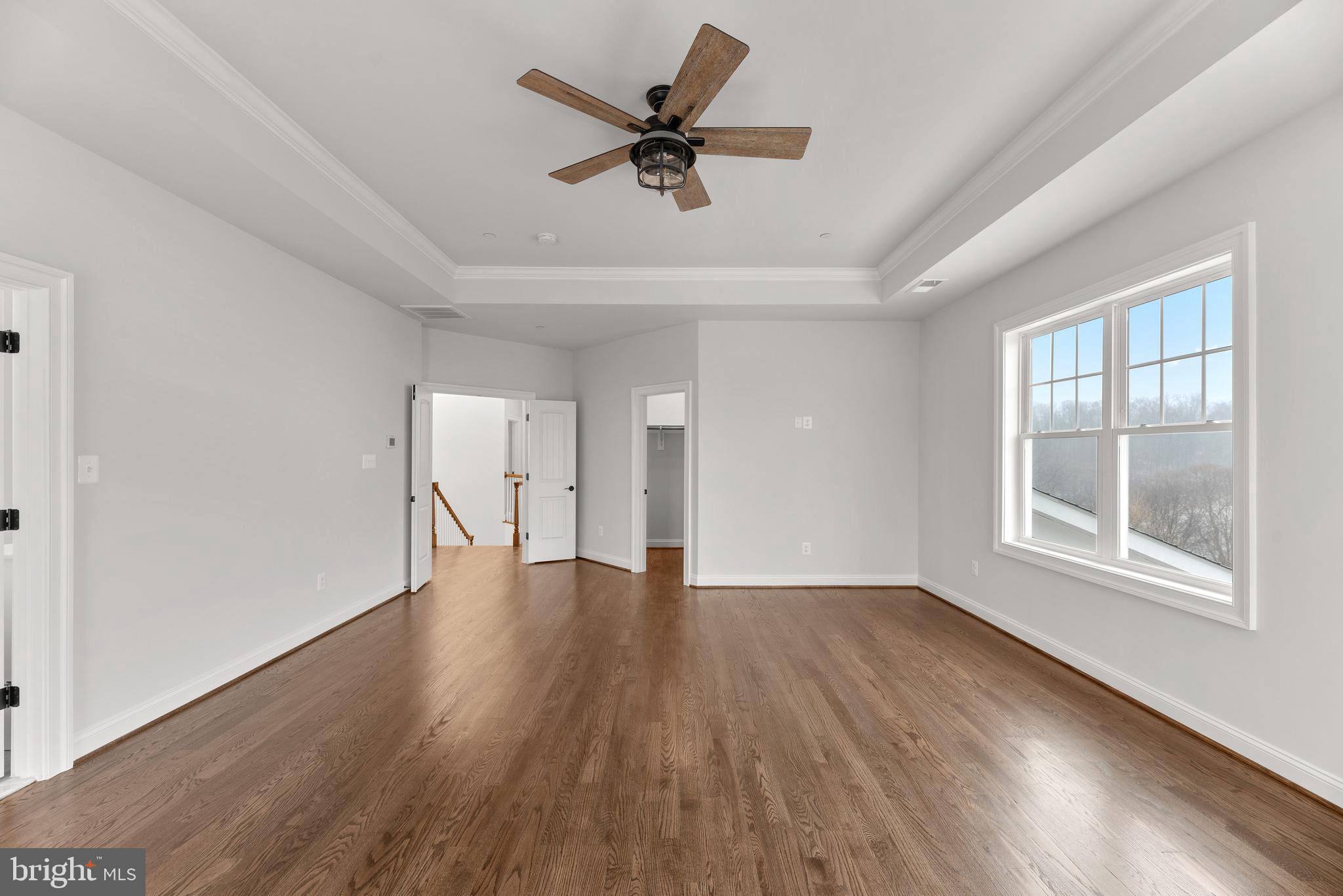 14628 Old Hanover Road, Unit TULARE Reisterstown, MD 21136 - Photo 32 of 60 an empty room with wooden floor chandelier fan and windows