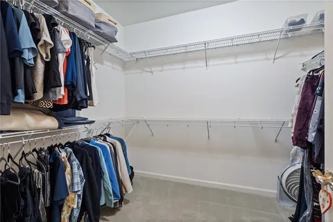 a view of walk in closet with clothes and shoes