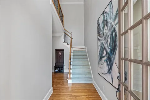 a view of a hallway with wooden floor and staircase