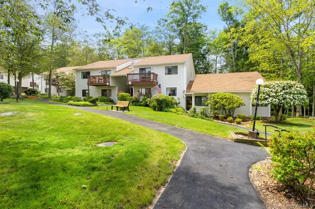 a view of a house with a yard and sitting area