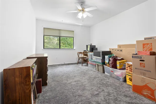 a view of a workspace with furniture and a window