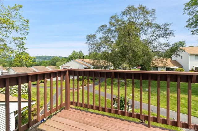 a view of a balcony with wooden floor & fence