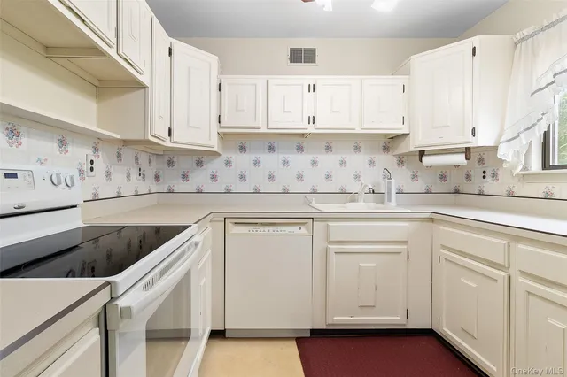 a kitchen with granite countertop white cabinets and white appliances