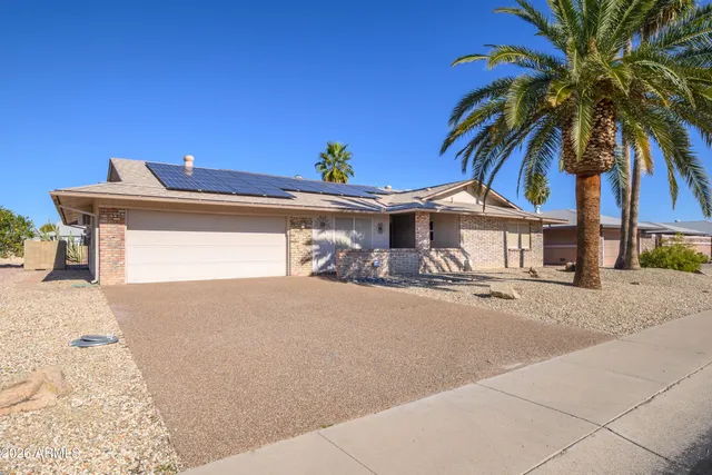 a view of a house with a yard and potted plants