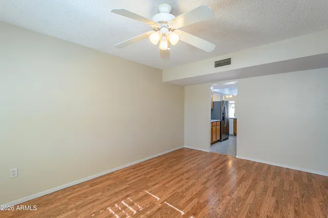 a view of a room with wooden floor and a ceiling fan