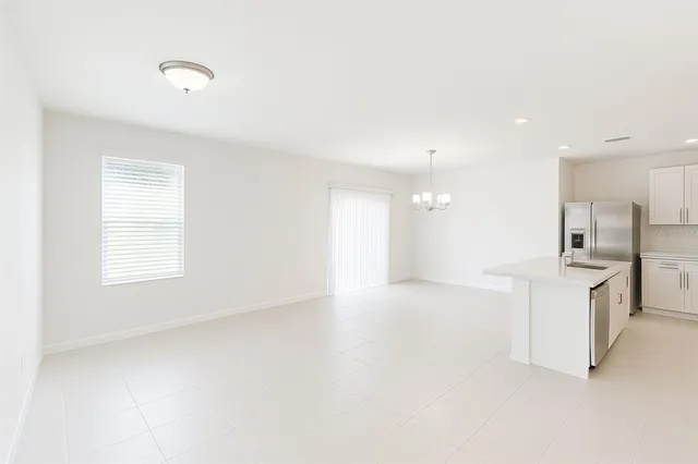 a view of an empty room with a kitchen