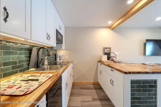 a kitchen with a sink and a wooden floor