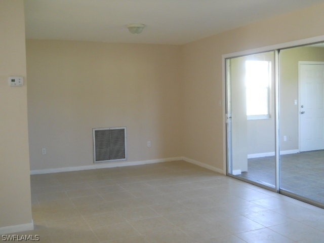 803 East Bougainvillea Road Lehigh Acres, FL 33936 - Photo 11 of 20 an empty room with wooden floor and windows