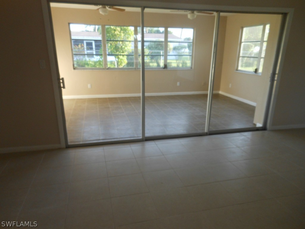 803 East Bougainvillea Road Lehigh Acres, FL 33936 - Photo 12 of 20 an empty room with wooden floor and windows