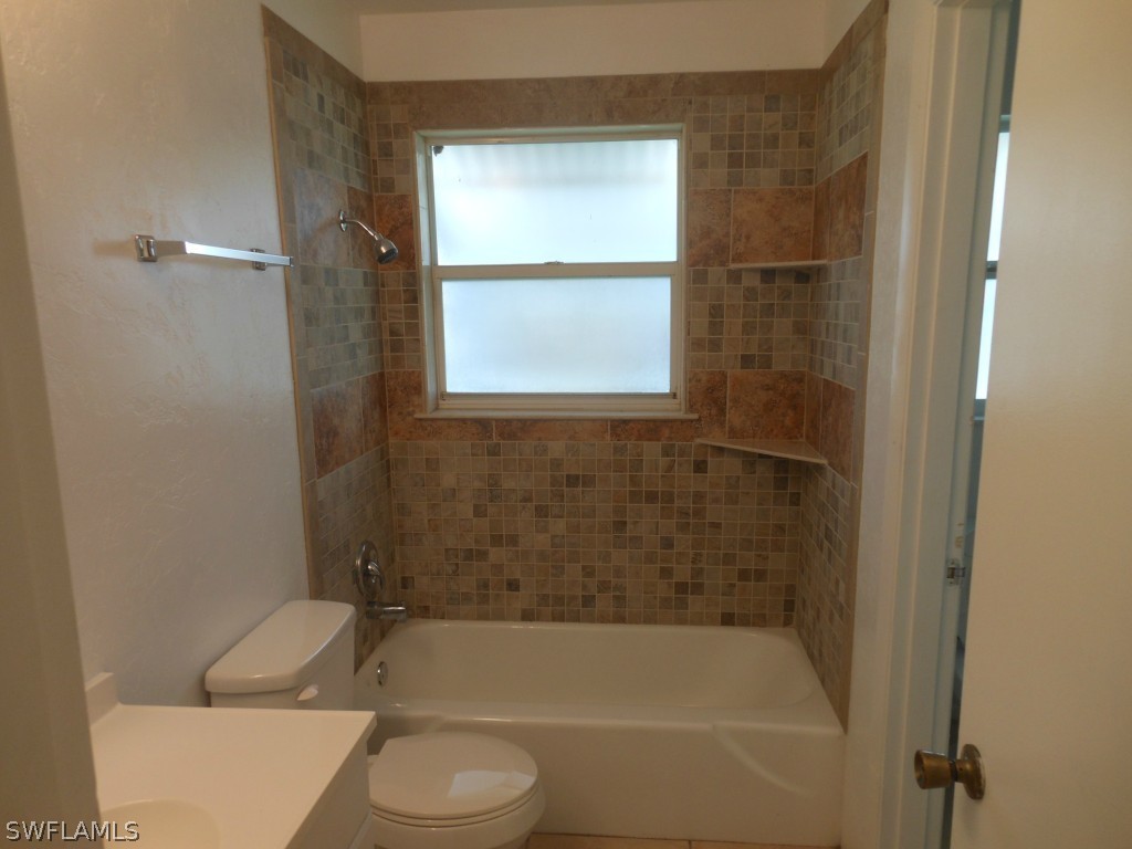803 East Bougainvillea Road Lehigh Acres, FL 33936 - Photo 16 of 20 a bathroom with a bathtub toilet and window