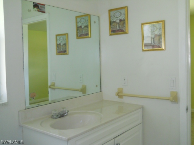803 East Bougainvillea Road Lehigh Acres, FL 33936 - Photo 17 of 20 a bathroom with a sink and a mirror