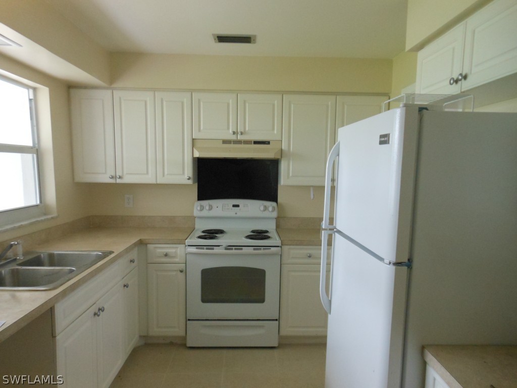 803 East Bougainvillea Road Lehigh Acres, FL 33936 - Photo 5 of 20 a kitchen with a stove a refrigerator and a sink