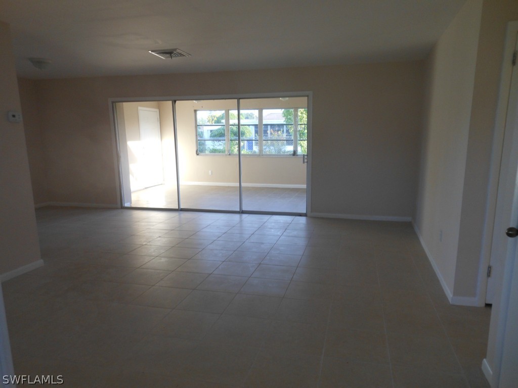 803 East Bougainvillea Road Lehigh Acres, FL 33936 - Photo 10 of 20 an empty room with wooden floor and windows