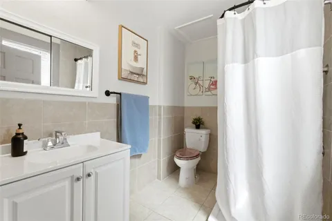 a bathroom with a sink a toilet and a shower curtain