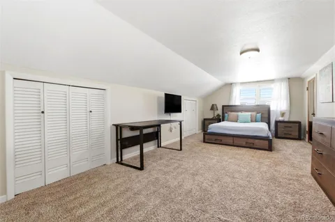 a bedroom with a bed and a tv on the dresser