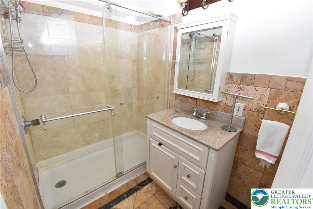 424 Grape Street Whitehall, PA 18052 - Photo 44 of 56 This bathroom features a contemporary vanity with a granite counter and a spacious glass-enclosed shower.