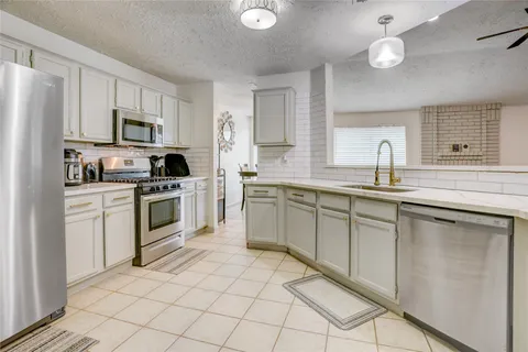 a kitchen with cabinets stainless steel appliances and sink