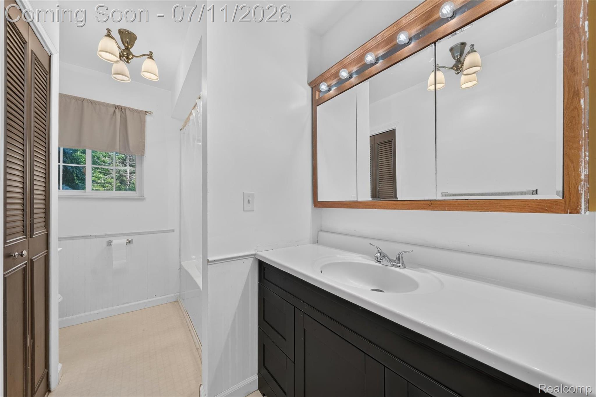 4430 North Center Road Flint, MI 48506 - Photo 15 of 49 Bathroom featuring a single vanity with an integrated sink, white countertop, and dark cabinetry