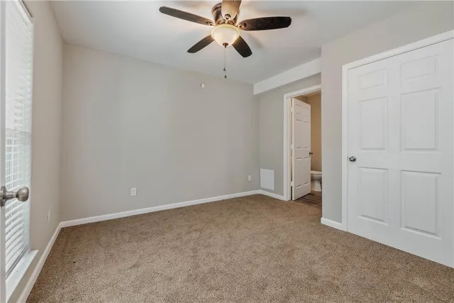 an empty room with chandelier fan