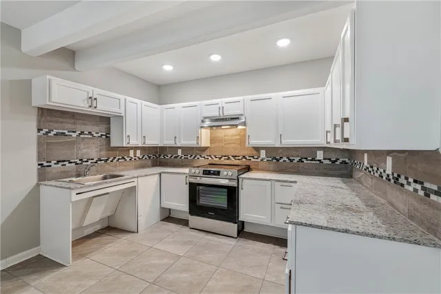a kitchen with granite countertop cabinets stainless steel appliances and a sink