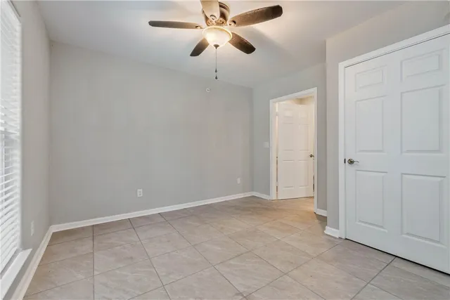 an empty room with closet and a chandelier fan