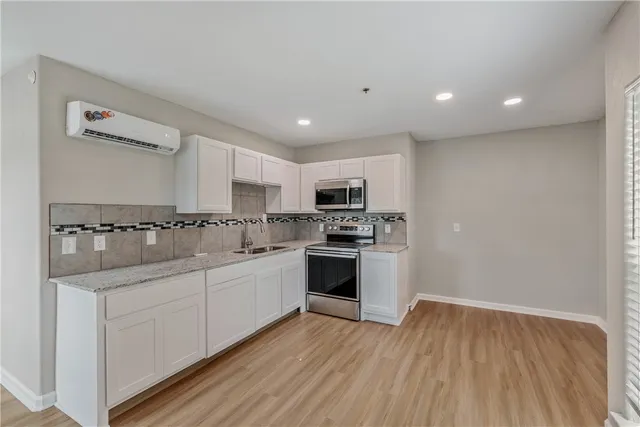 a kitchen with white cabinets and white appliances
