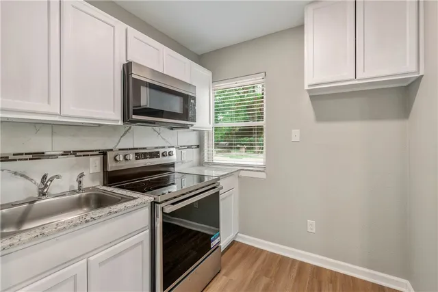 a kitchen with granite countertop cabinets stainless steel appliances and a sink