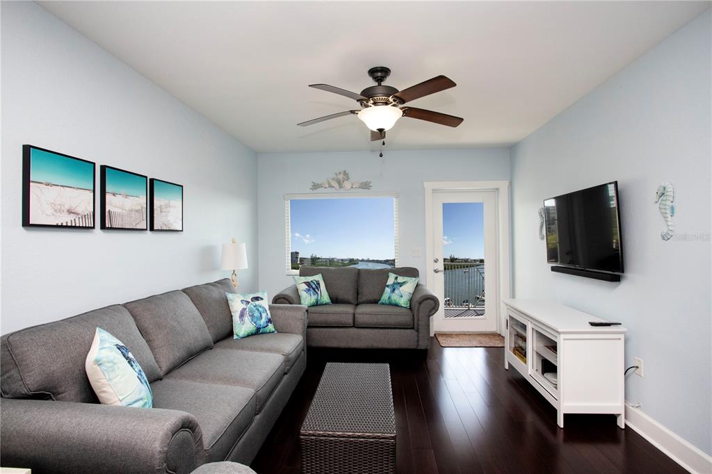 399 2nd Street, Unit 417 Indian Rocks Beach, FL 33785 - Photo 3 of 35 a living room with furniture and a flat screen tv