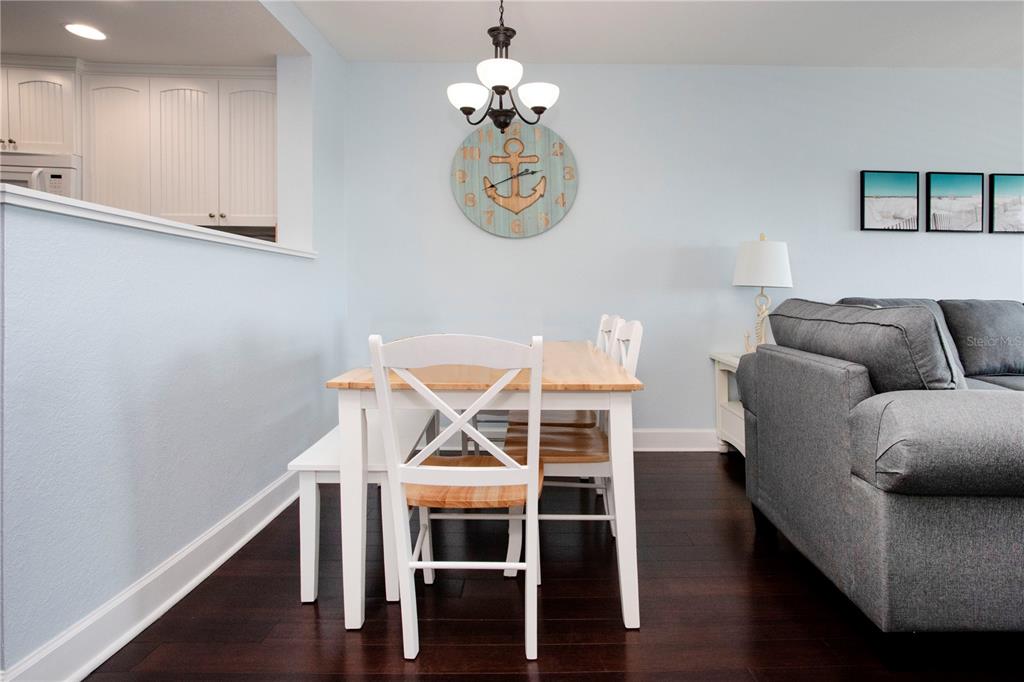 399 2nd Street, Unit 417 Indian Rocks Beach, FL 33785 - Photo 7 of 35 a view of a dining room with furniture wooden floor and a chandelier